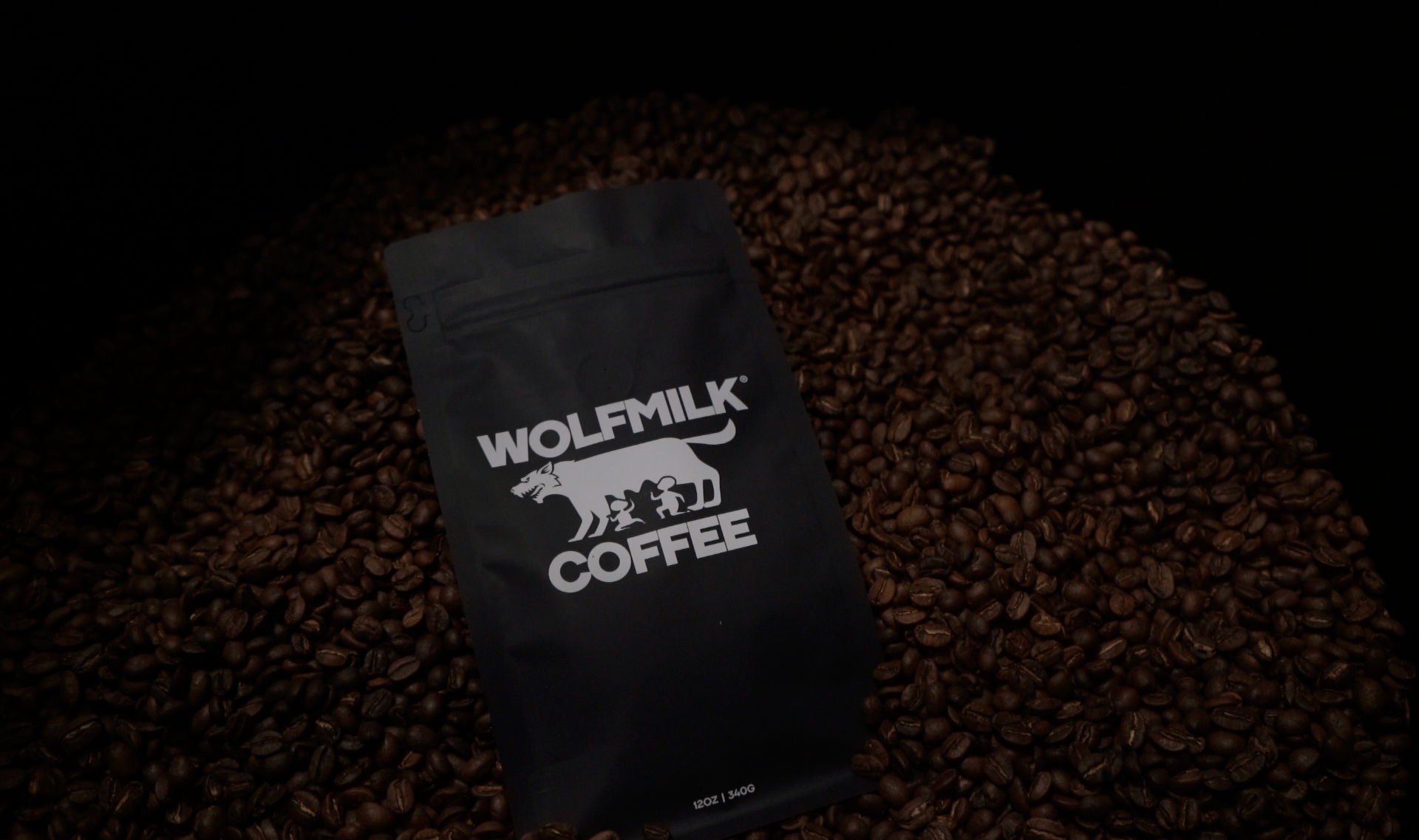 Wolfmilk Coffee bag surrounded by freshly roasted beans