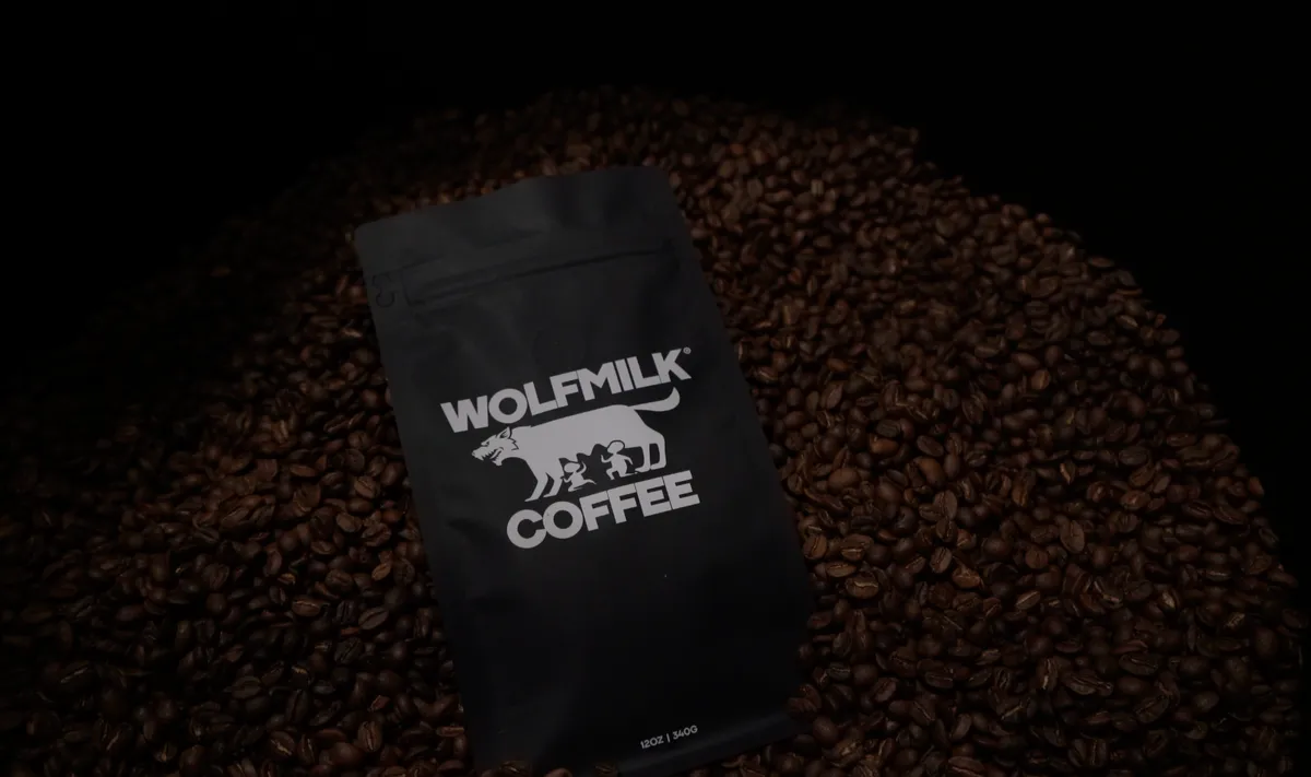 Wolfmilk Coffee bag surrounded by freshly roasted beans