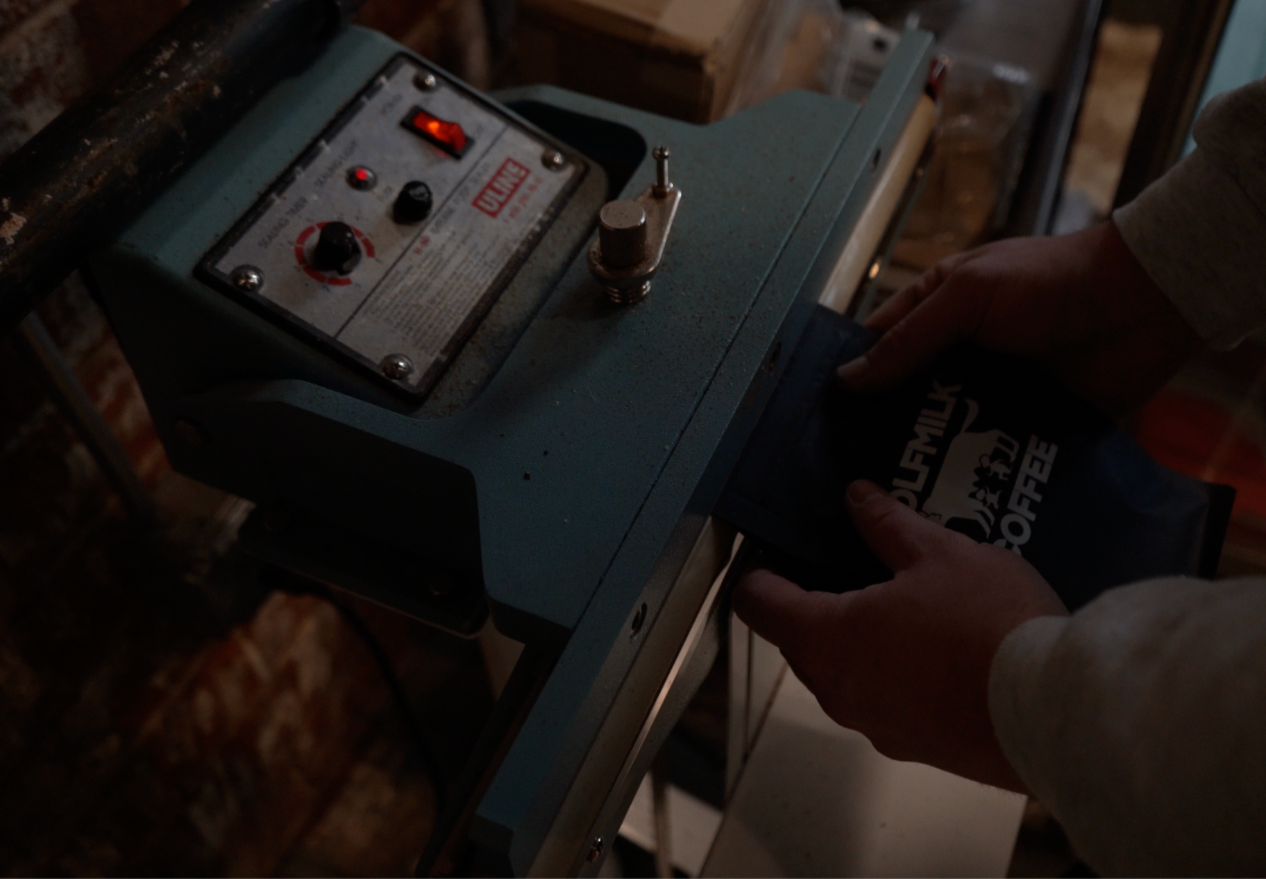 Hand-sealing Wolfmilk Coffee bags on packaging machine