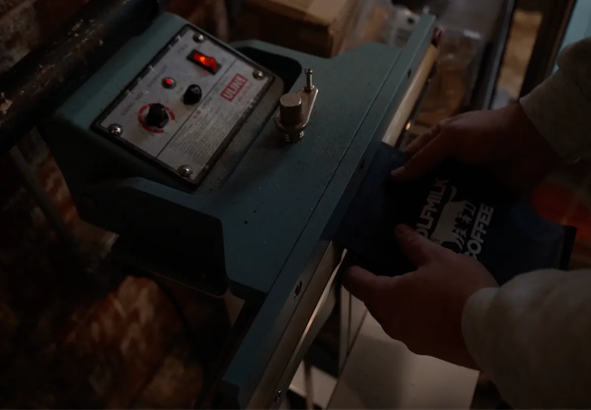 Hand-sealing Wolfmilk Coffee bags on packaging machine